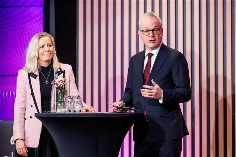 Kvinne og mann snakker på en konferanse